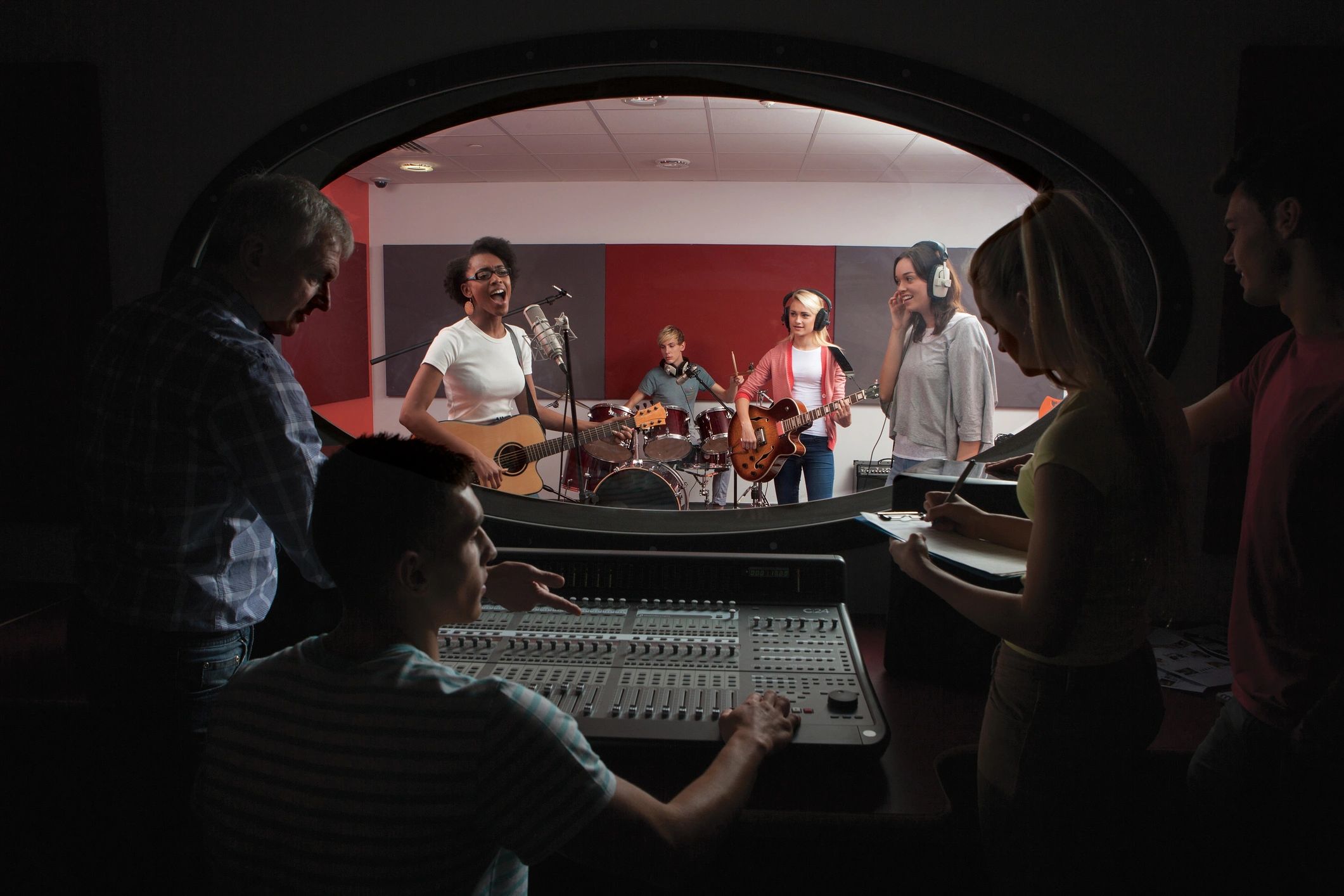Band with lead singer in recording studio